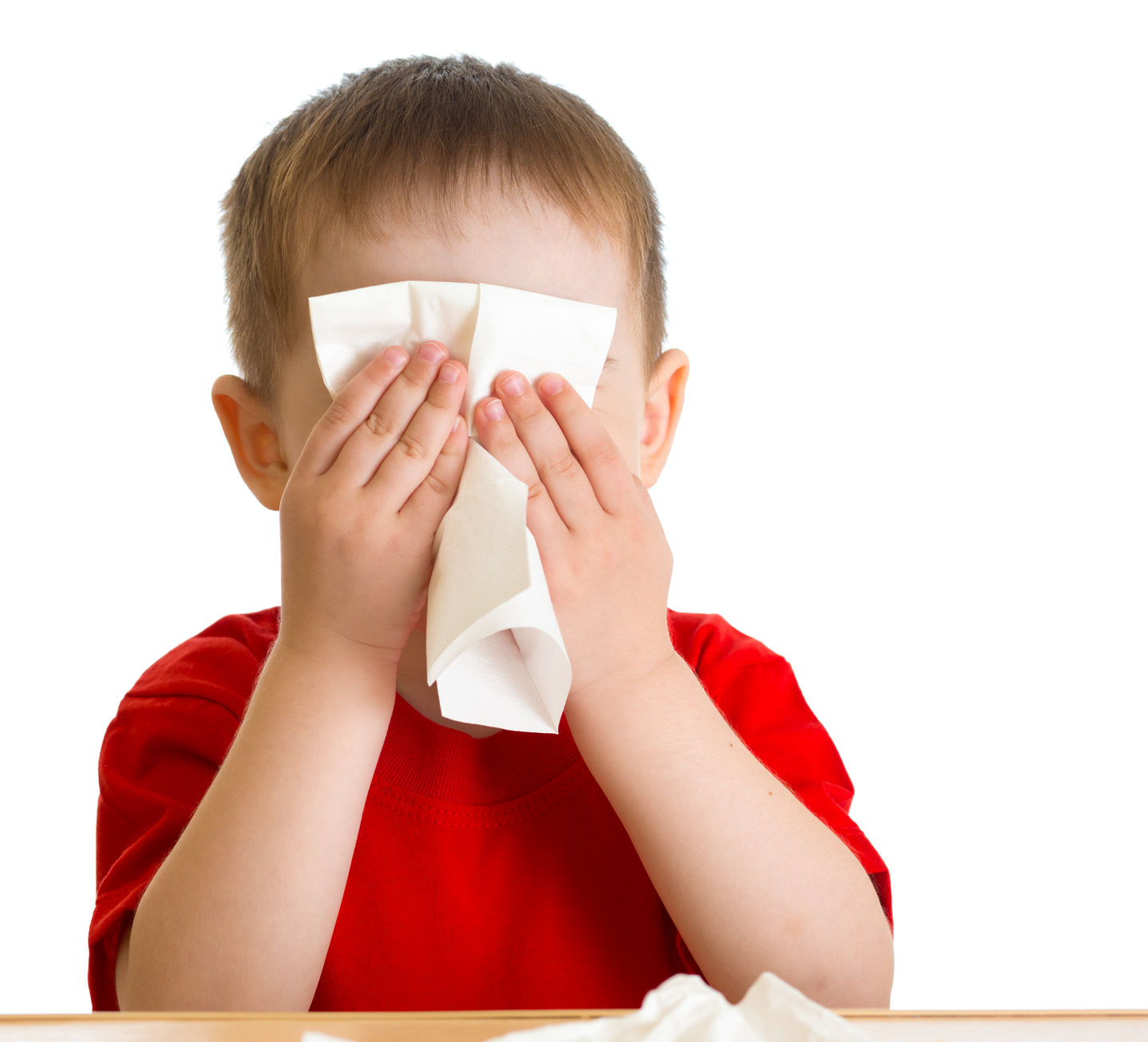 Niño con alergia sonándose